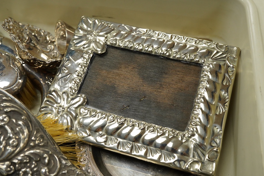 A small group of silver and white metal items, including an Edwardian silver and tortoiseshell mounted hand mirror by Samuel Jacob, 26.1cm, a silver mounted hair brush, a small silver mounted brush, a repousse silver pin